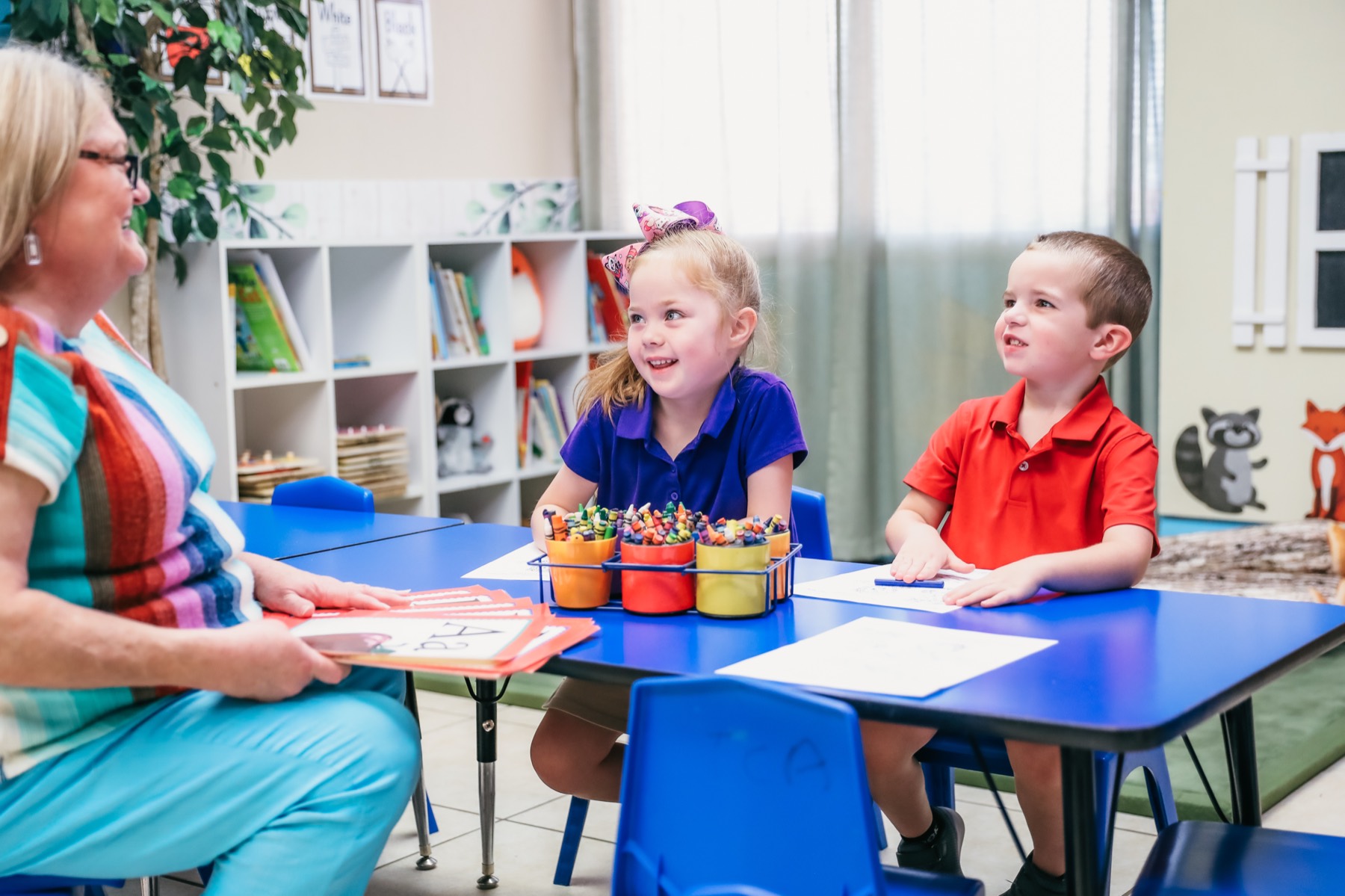 A Trinity Christian Academy teacher working with two young students