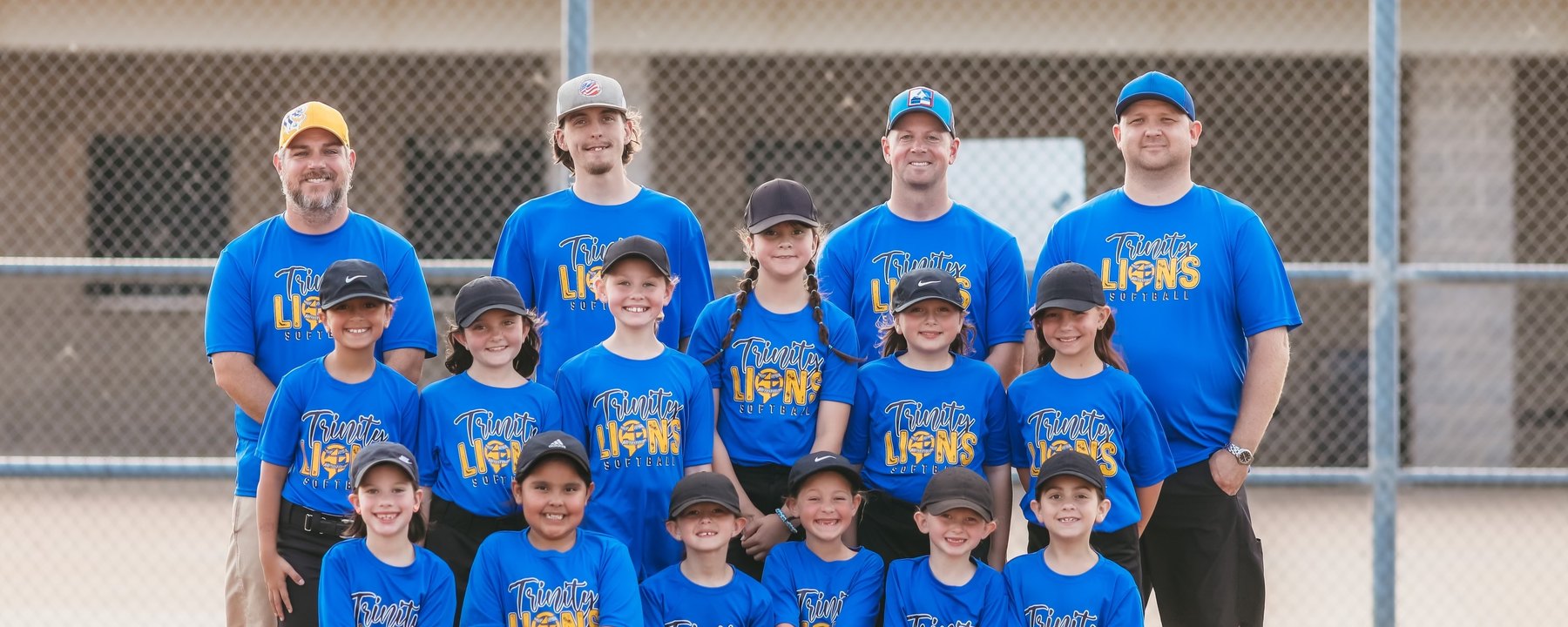 The Trinity Christian Academy Lions softball team and their coaches on the field